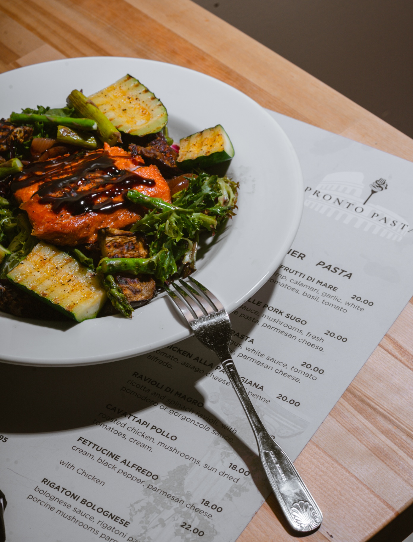 Balsamic-glazed salmon with grilled vegetables over the menu